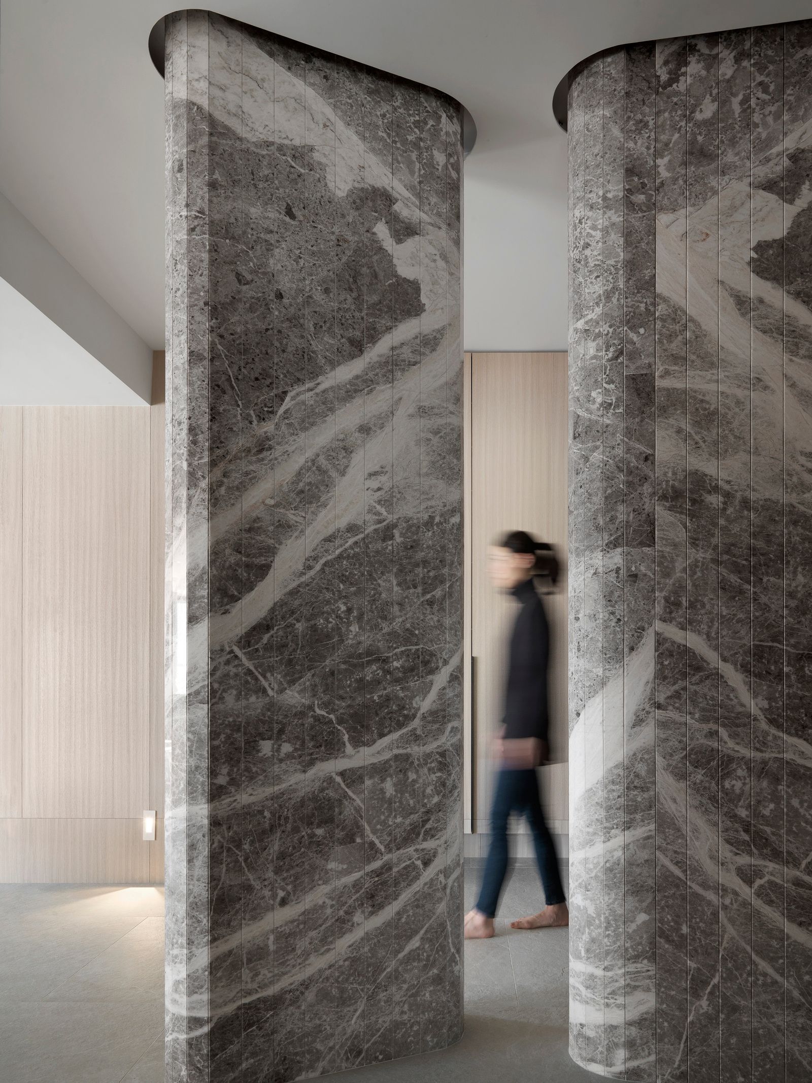 Curved marble column cladding in a refined interior corridor