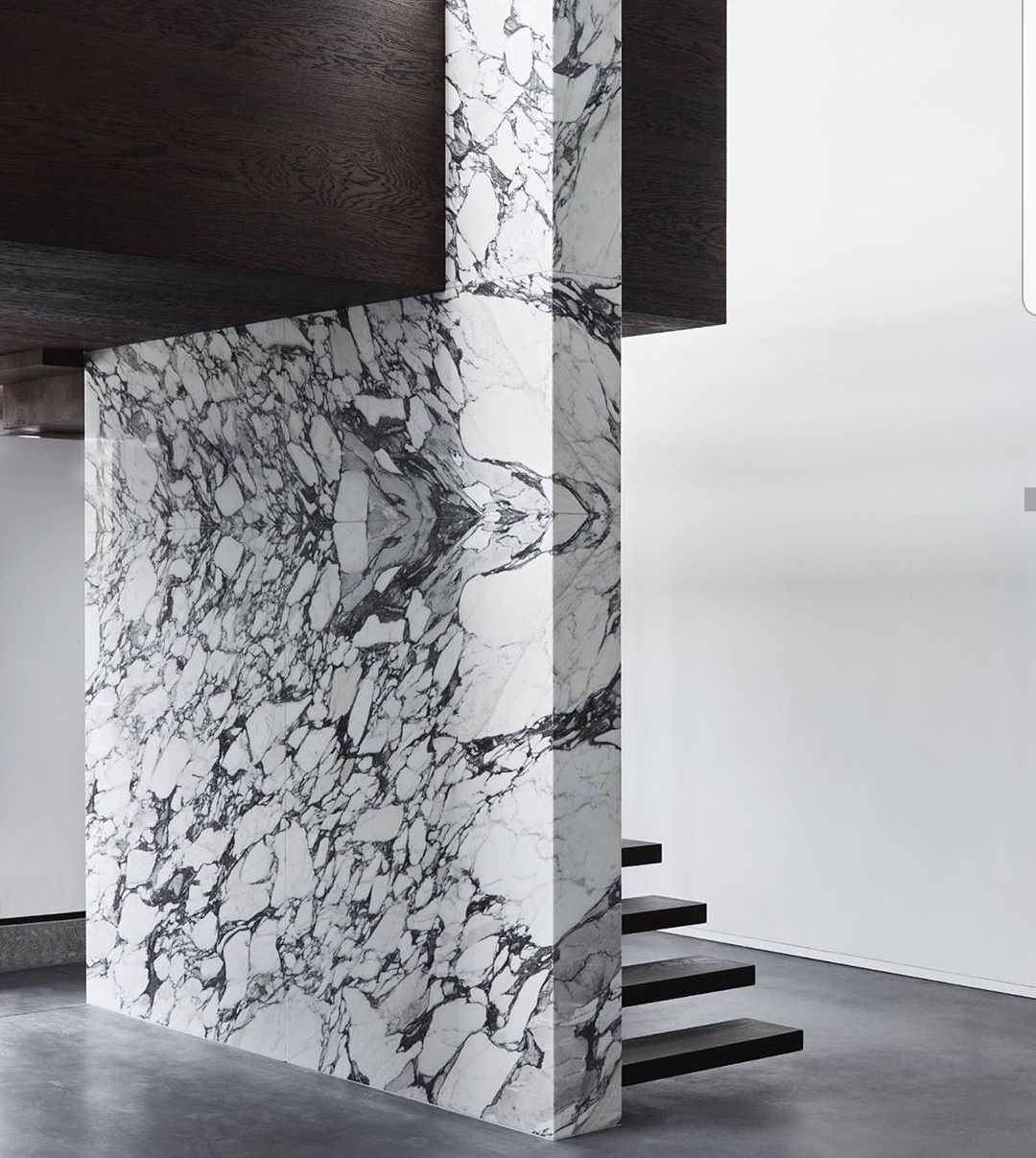 Marble structural column wrap with bookmatched stone panels