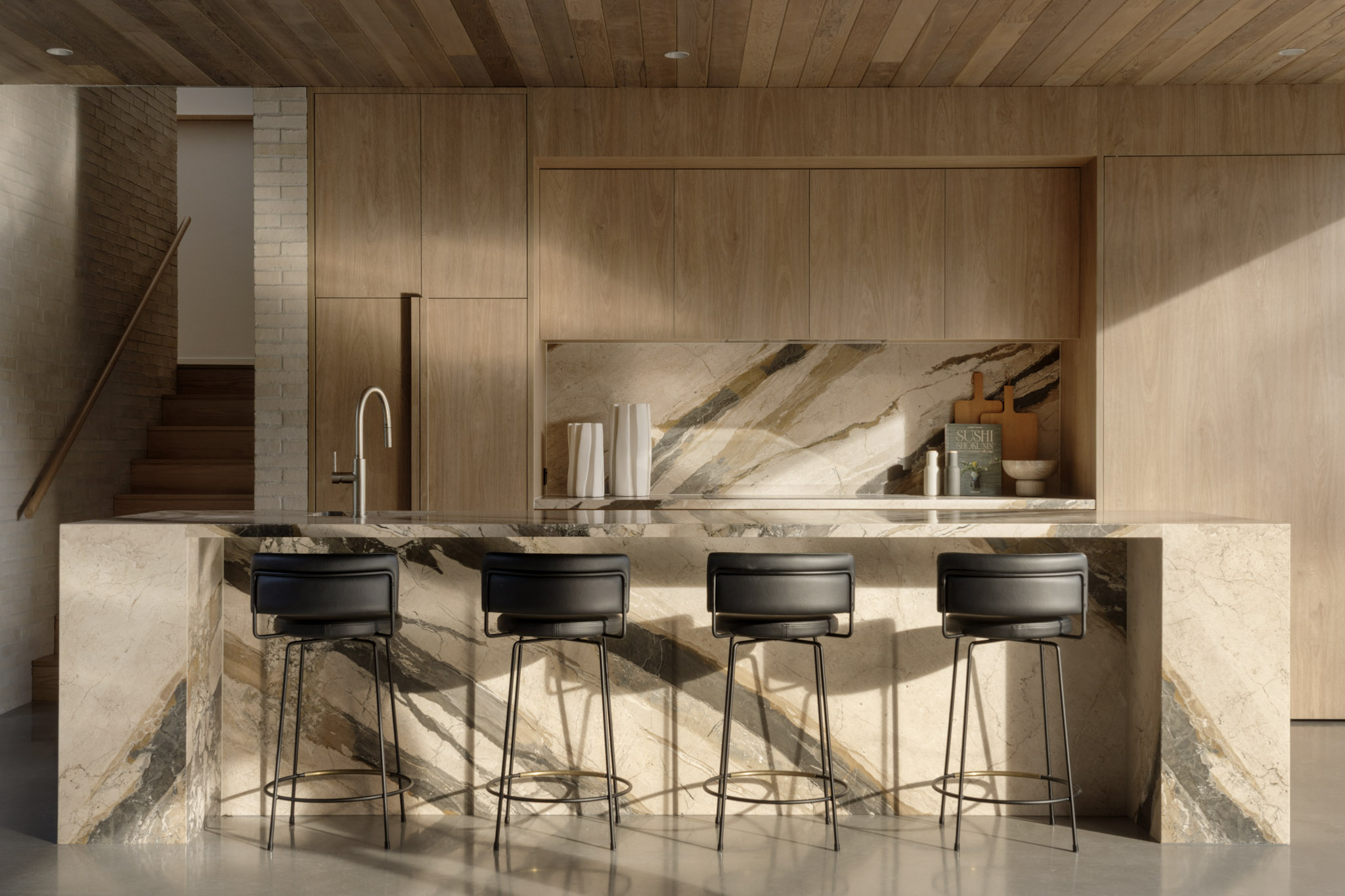 Sunlit kitchen island with waterfall natural stone countertop