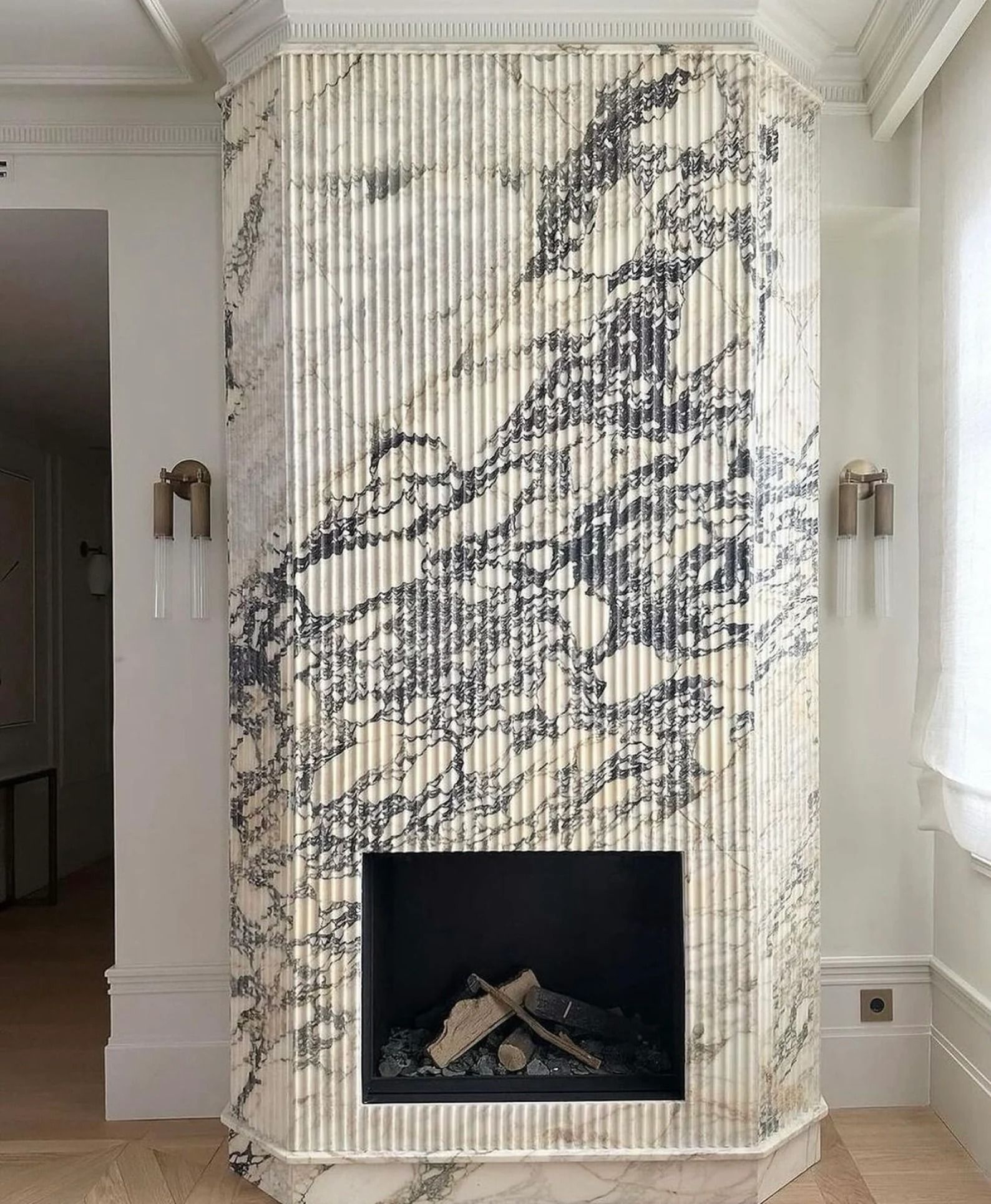 Fluted white marble fireplace feature wall with dark veining
