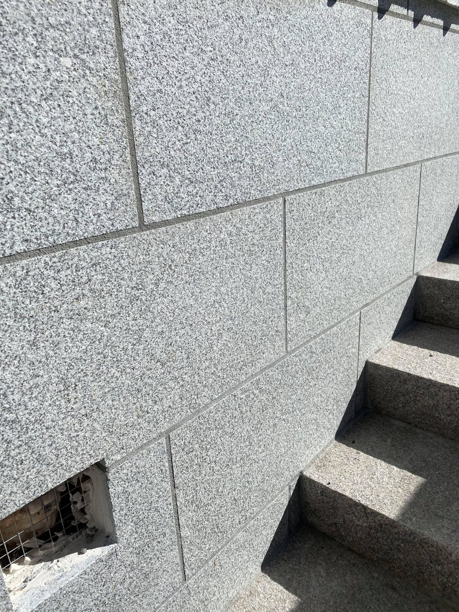 Bush-hammered granite facade cladding and stair detail