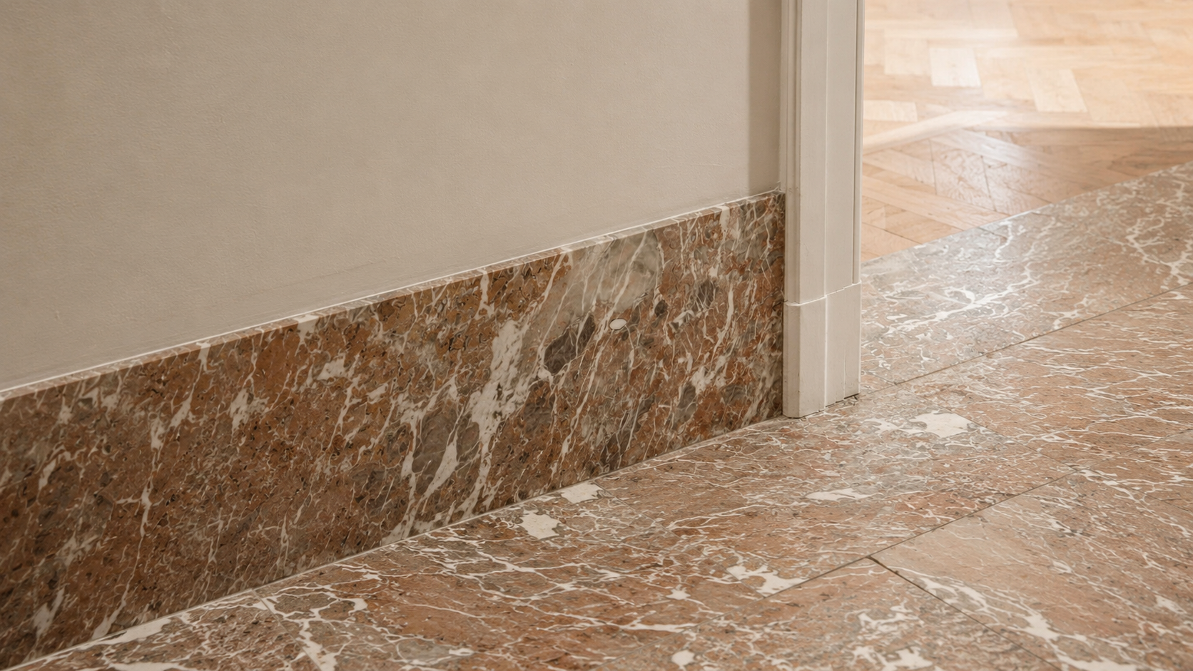 Brown marble skirting aligned with matching floor stone beside a doorway