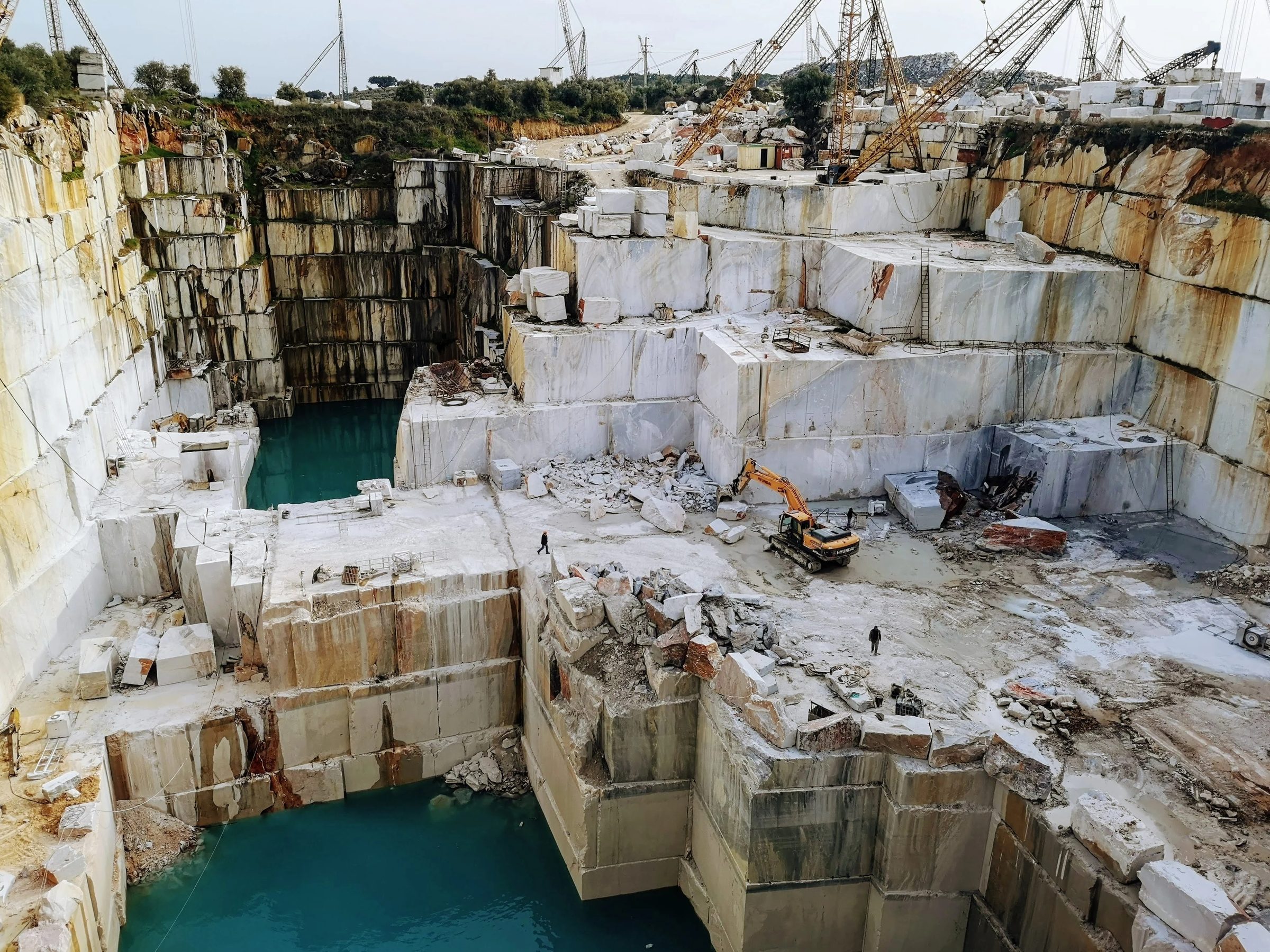 Natural stone quarry with marble blocks and cranes