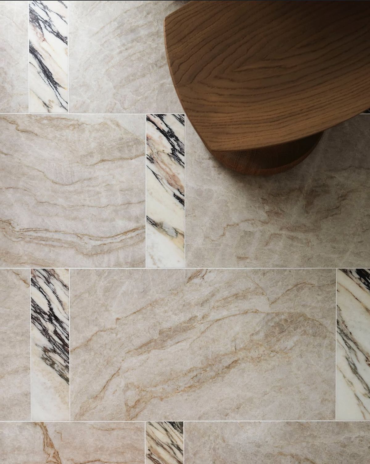 Mixed natural stone tile layout with alternating marble inserts